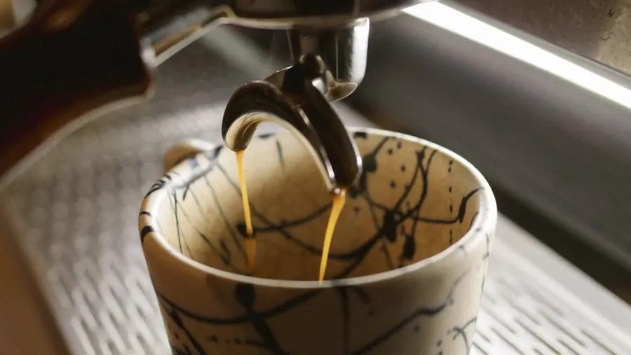 Espresso cayendo en una taza de cerámica