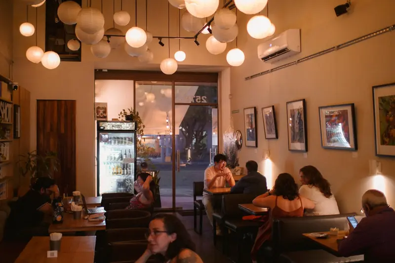 Salón de Dailyshot de noche, con lámparas de papel y gente en las mesas